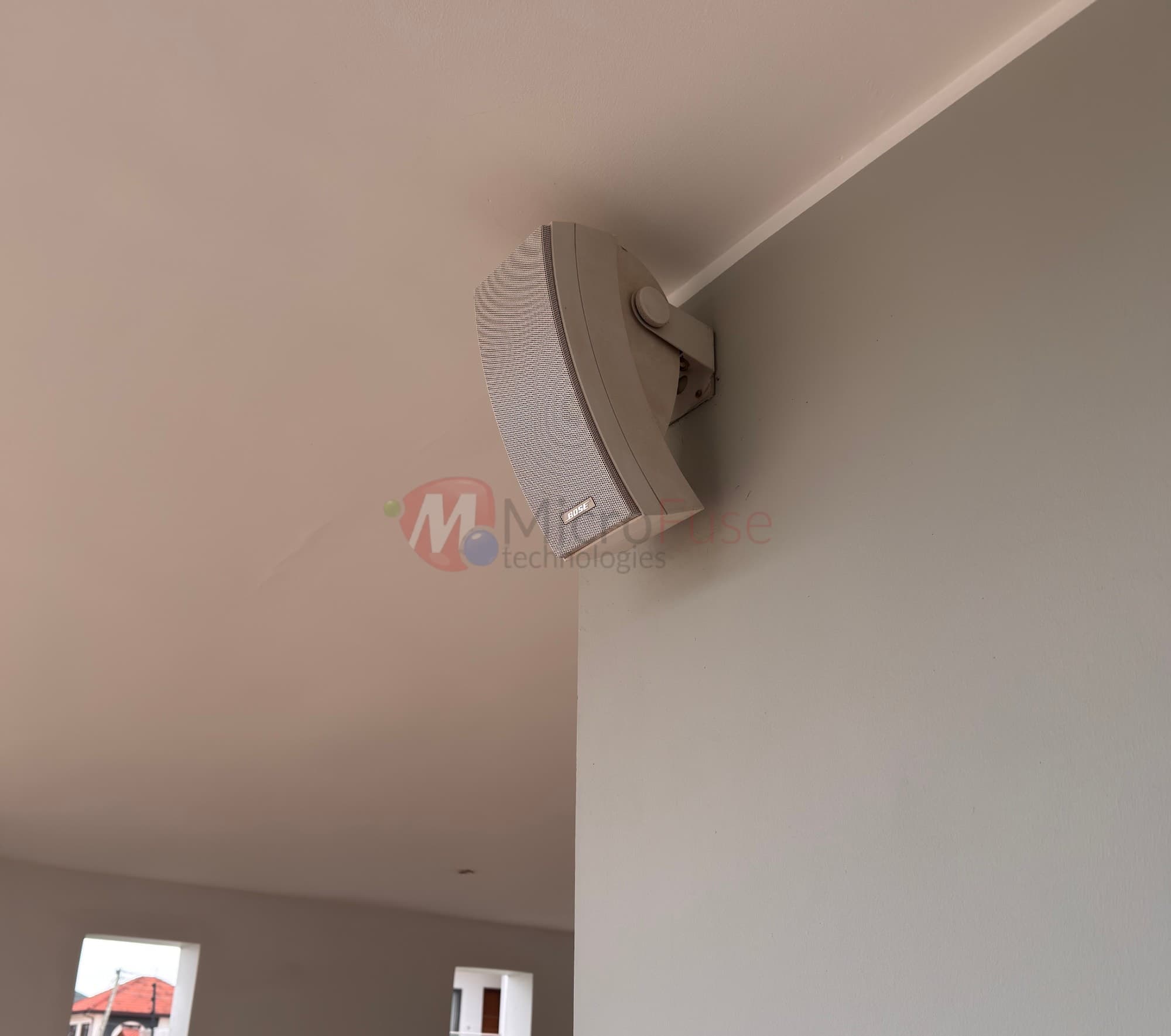 Bose speaker mounted at a wall-ceiling corner